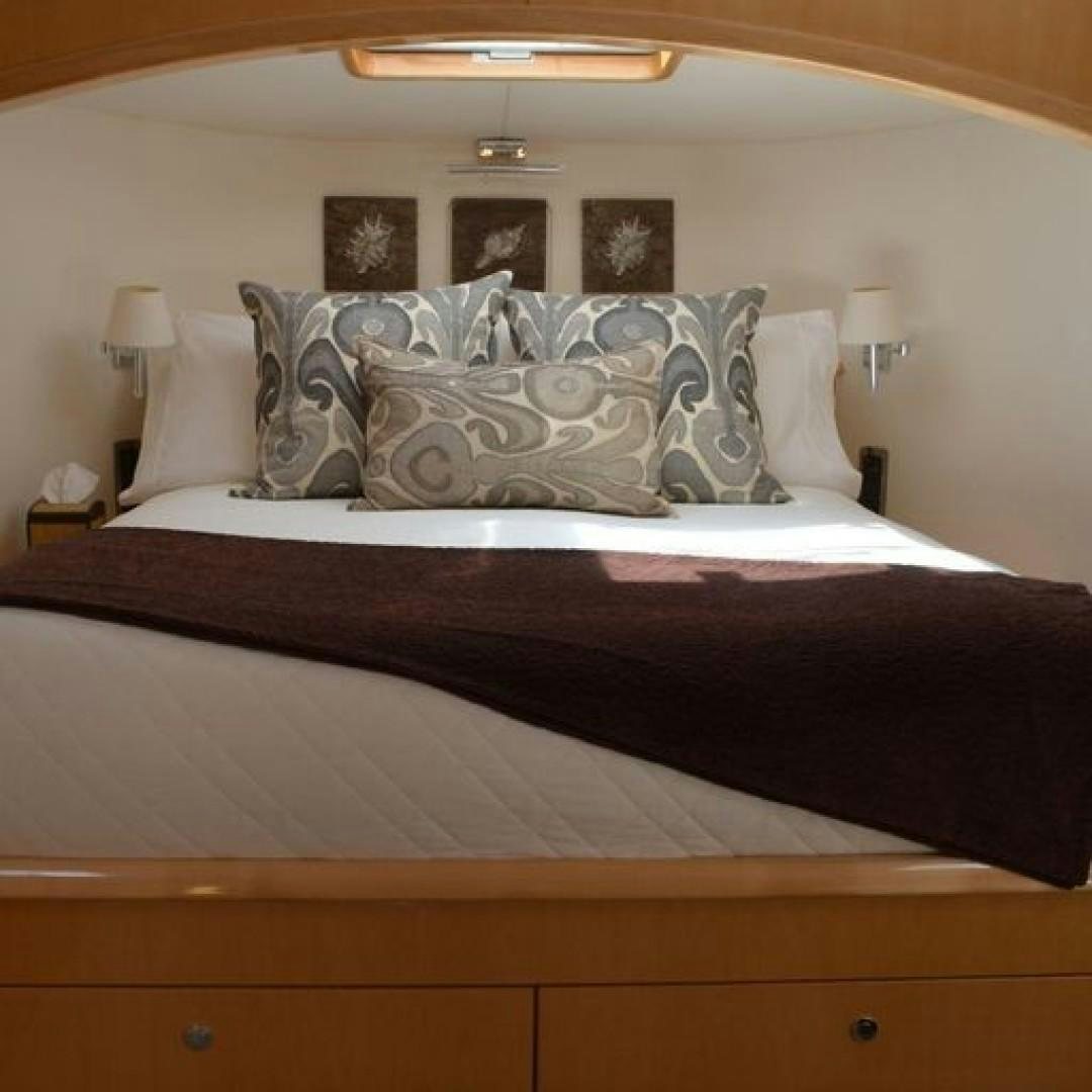 a bed with a black and white bed spread aboard MATAU Yacht for Sale