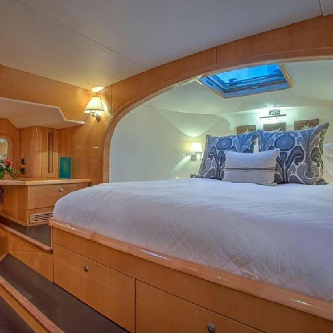 a bed with a blue pillow aboard MATAU Yacht for Sale
