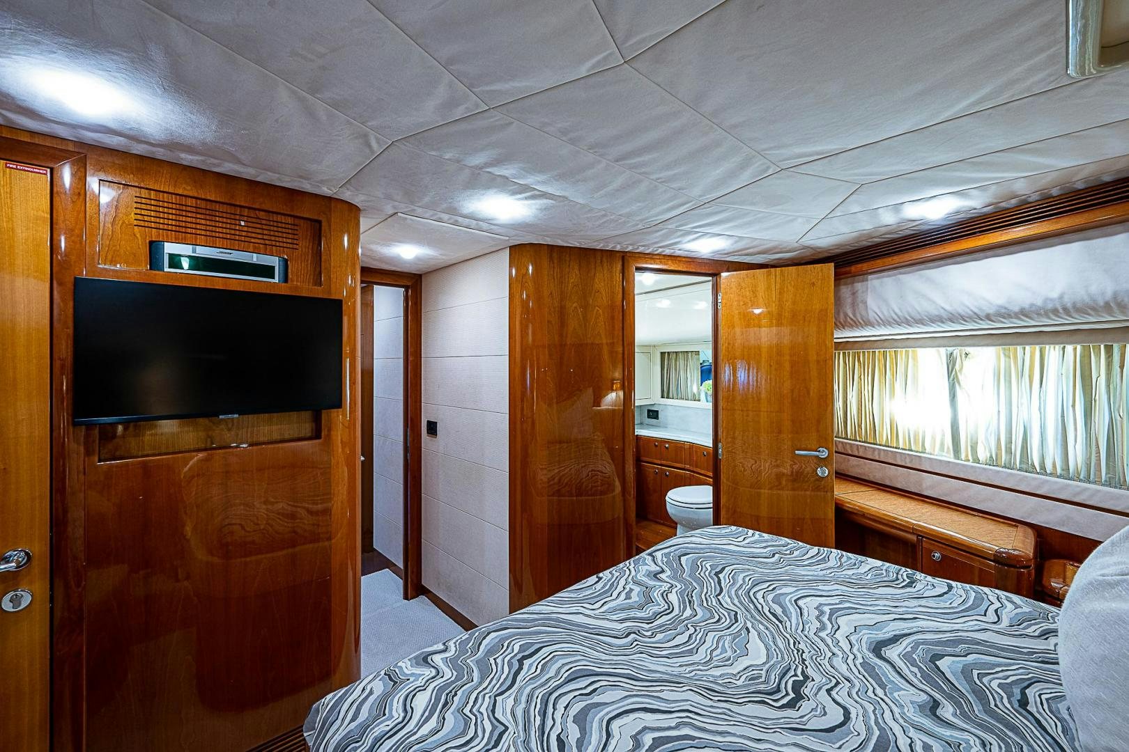 a bedroom with a bed and a television aboard LA BELLA VITA Yacht for Sale