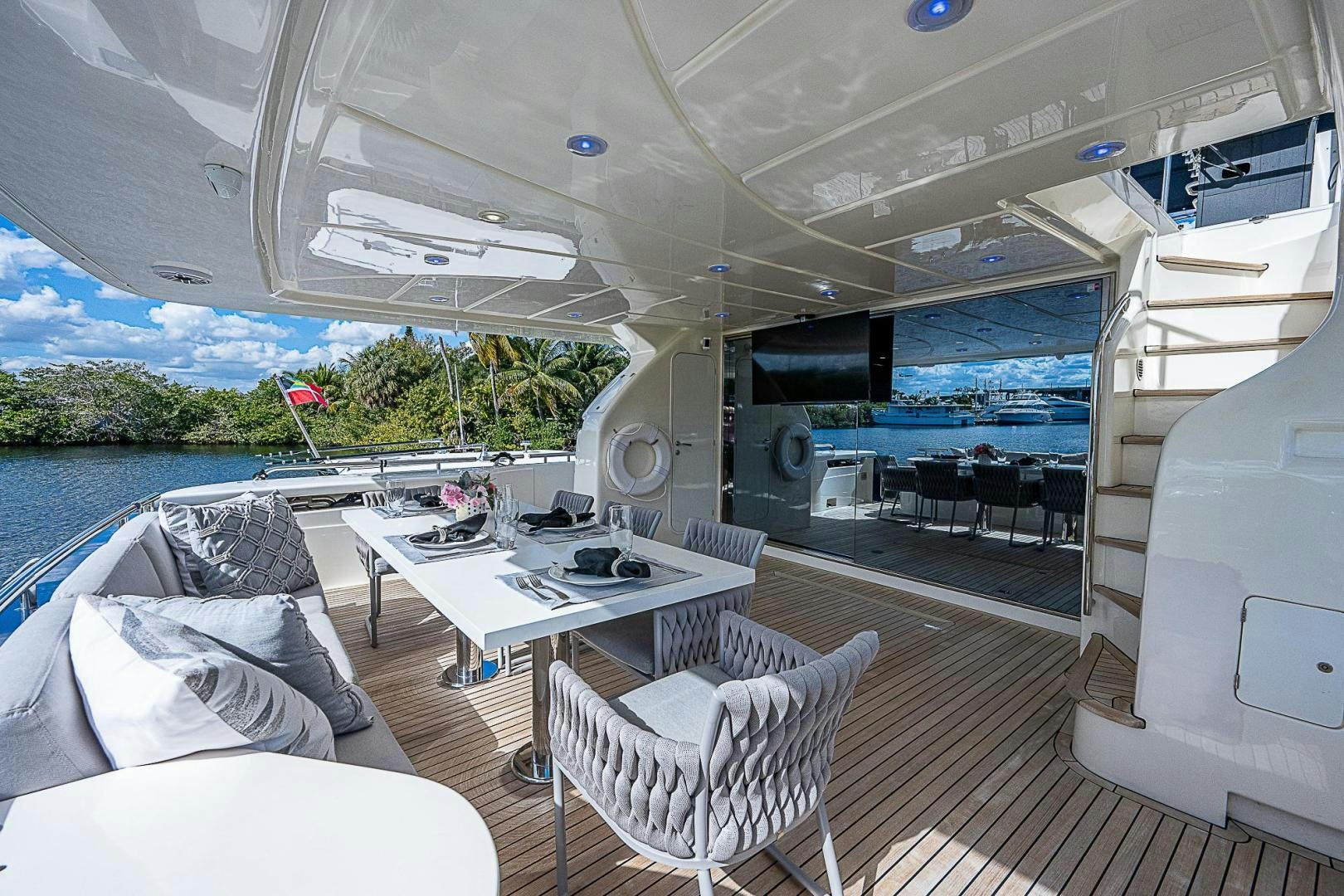 a room with a table chairs and a large window with a view of the water aboard LA BELLA VITA Yacht for Sale