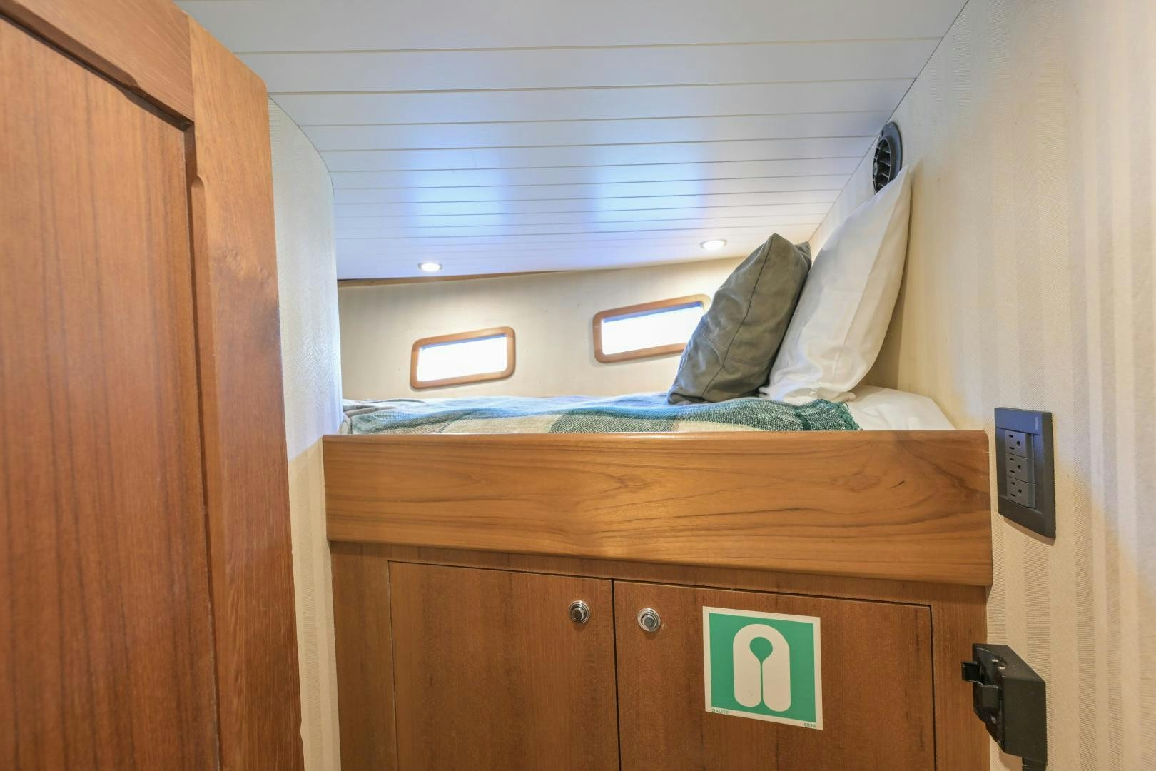 a bed with a green sign on it aboard CHEEMAUN Yacht for Sale