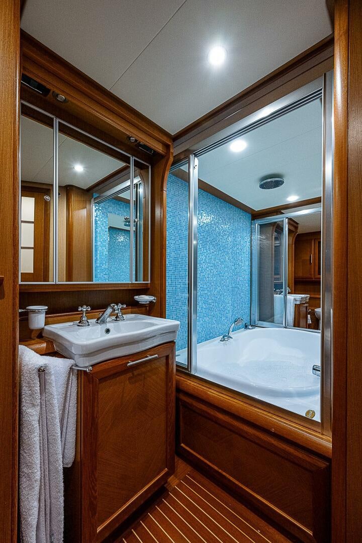 a bathroom with a tub sink and a mirror aboard KNOT NANNY'S Yacht for Sale