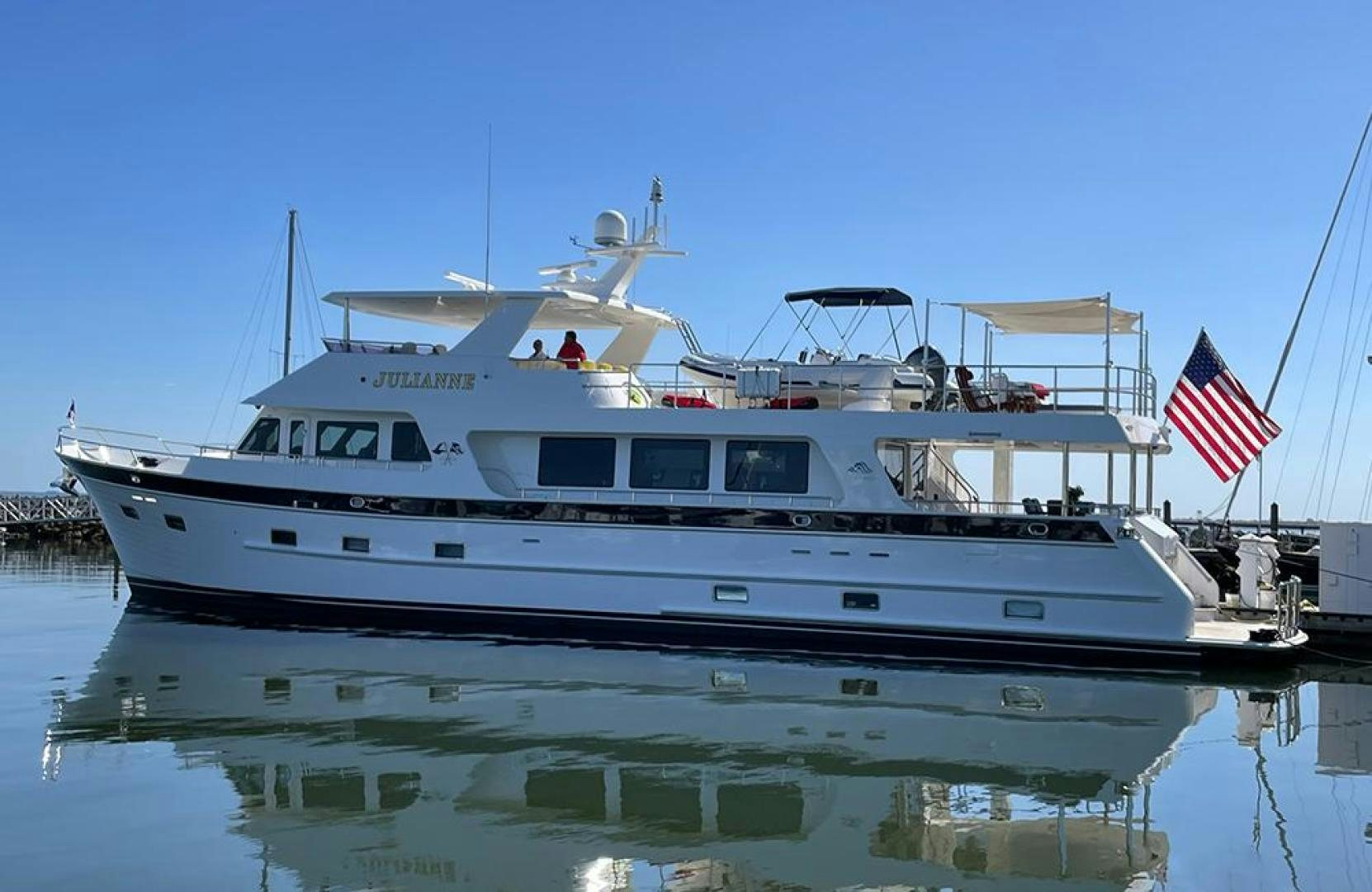 a large white boat with a flag on the front aboard JULIANNE NAME RESERVED Yacht for Sale