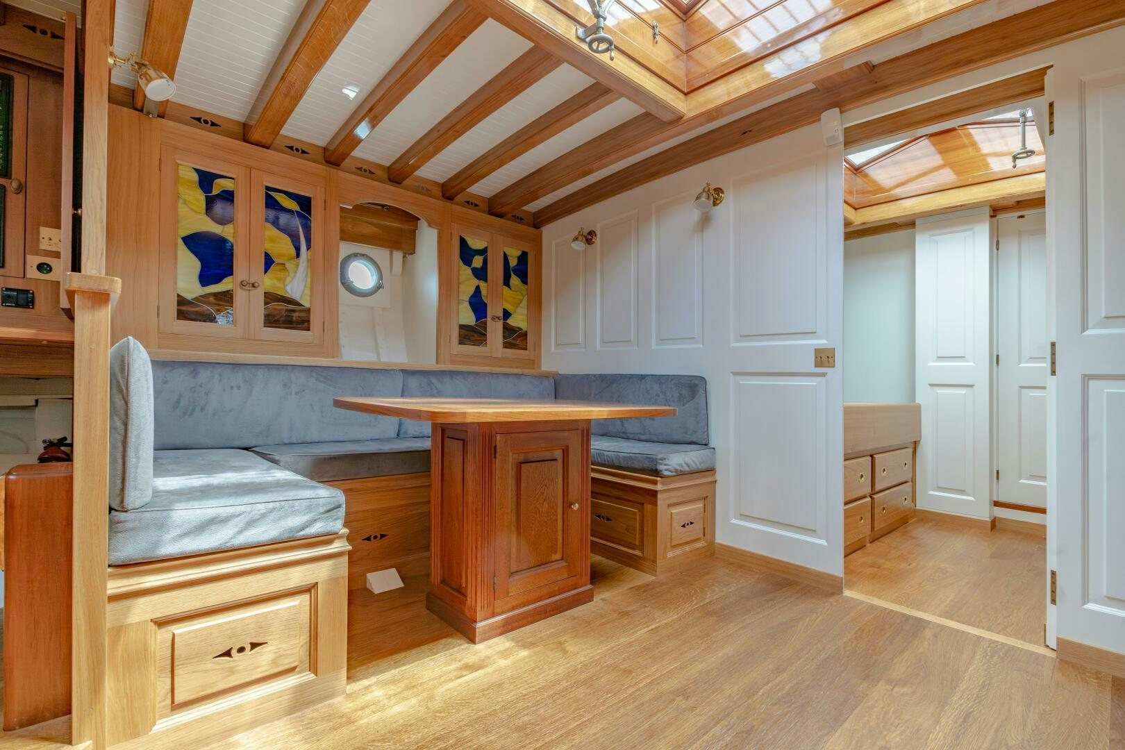 a room with a table and a bed aboard ARMIDE Yacht for Sale