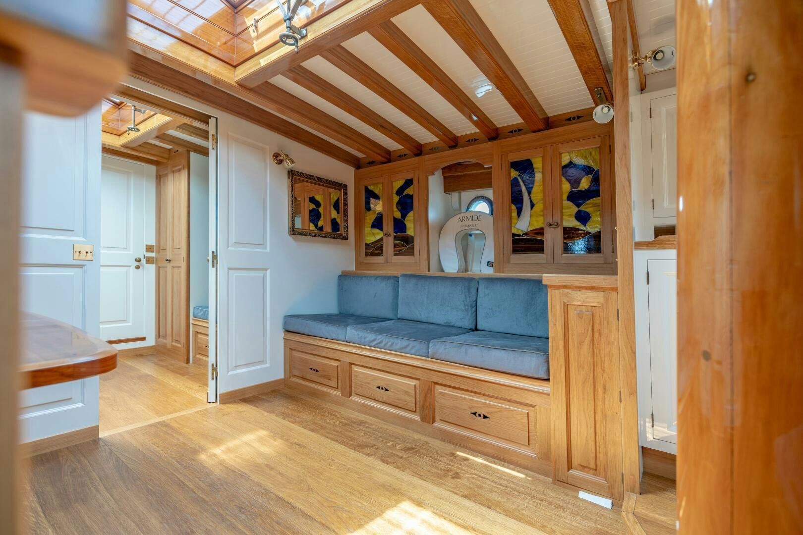 a room with a wood floor and a blue couch aboard ARMIDE Yacht for Sale