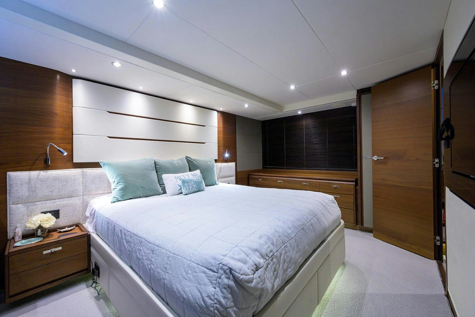 a bedroom with a bed and a dresser aboard KHATCH YOU LATER Yacht for Sale