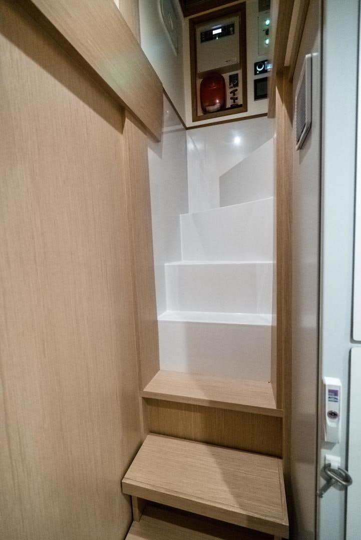 a wooden cabinet with a microwave and a refrigerator aboard BEL SOGNO Yacht for Sale