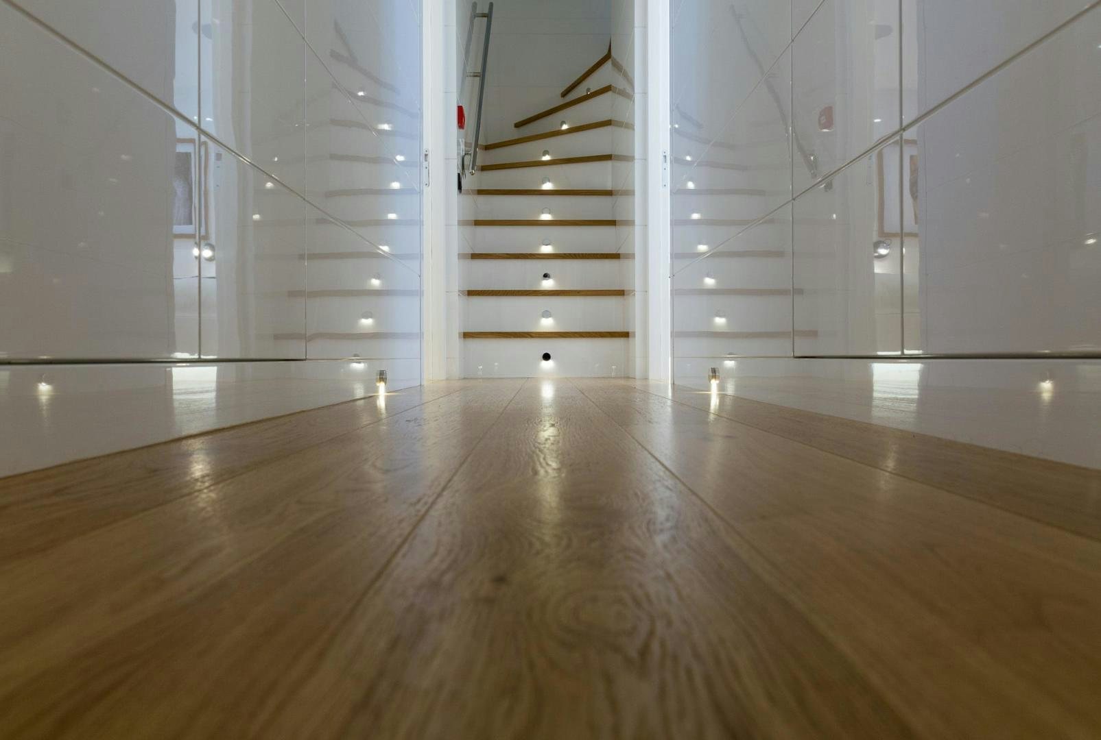 a room with white walls and wood floors aboard HEKATE, P372 Yacht for Sale