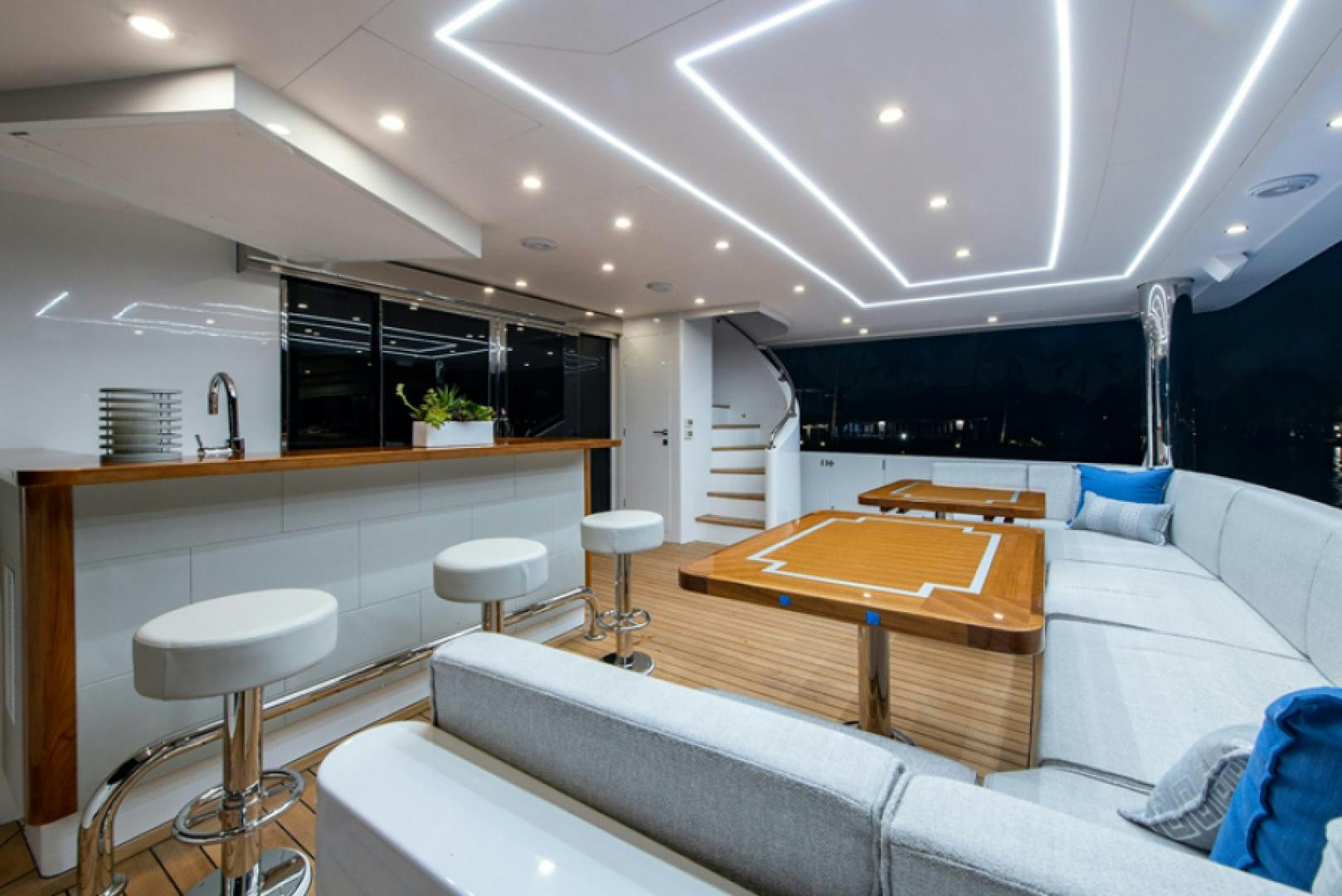 a modern looking room with a large white kitchen and a large island aboard CONGVOYAGE Yacht for Sale