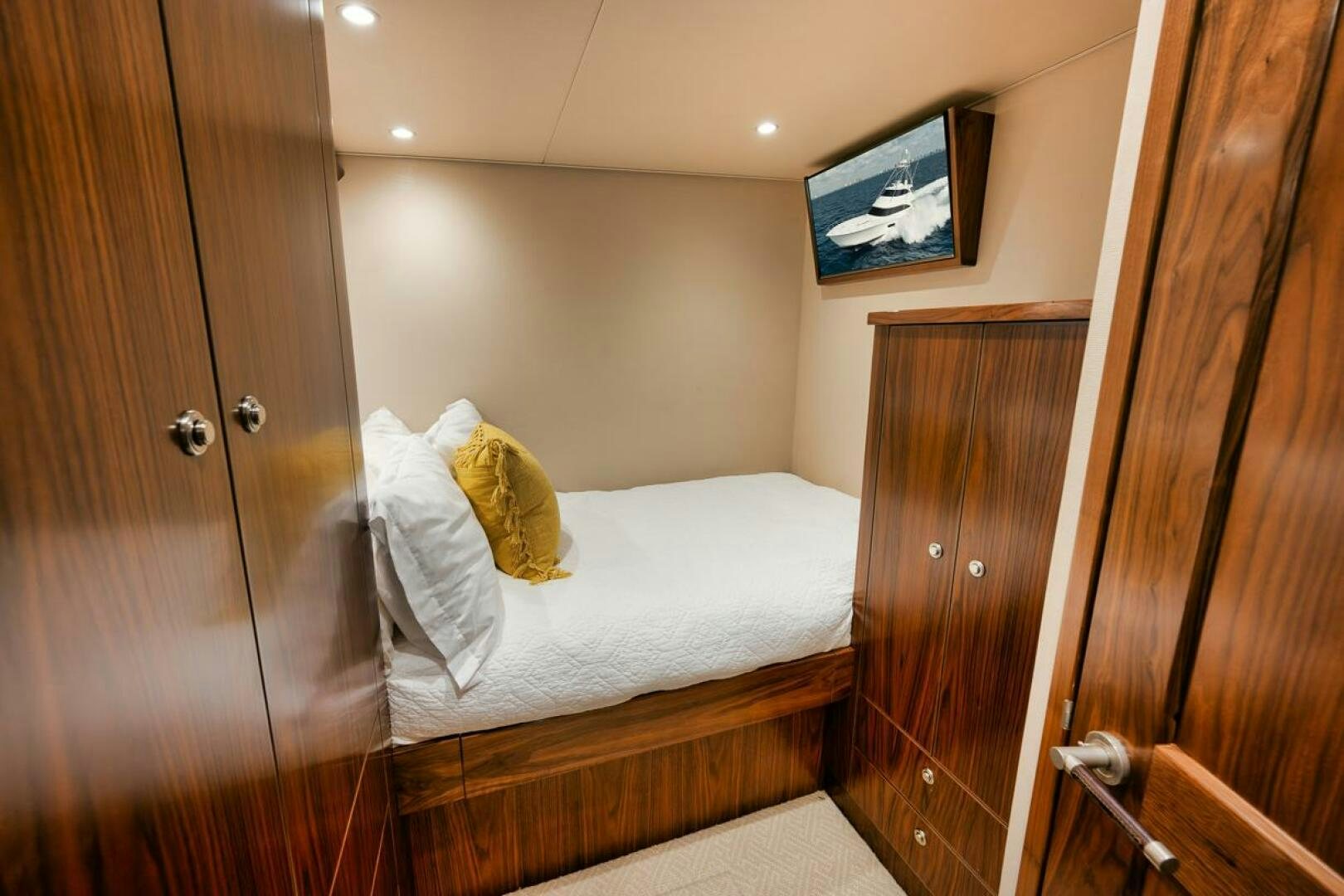 a bed with a television on the wall aboard FA-LA-ME Yacht for Sale