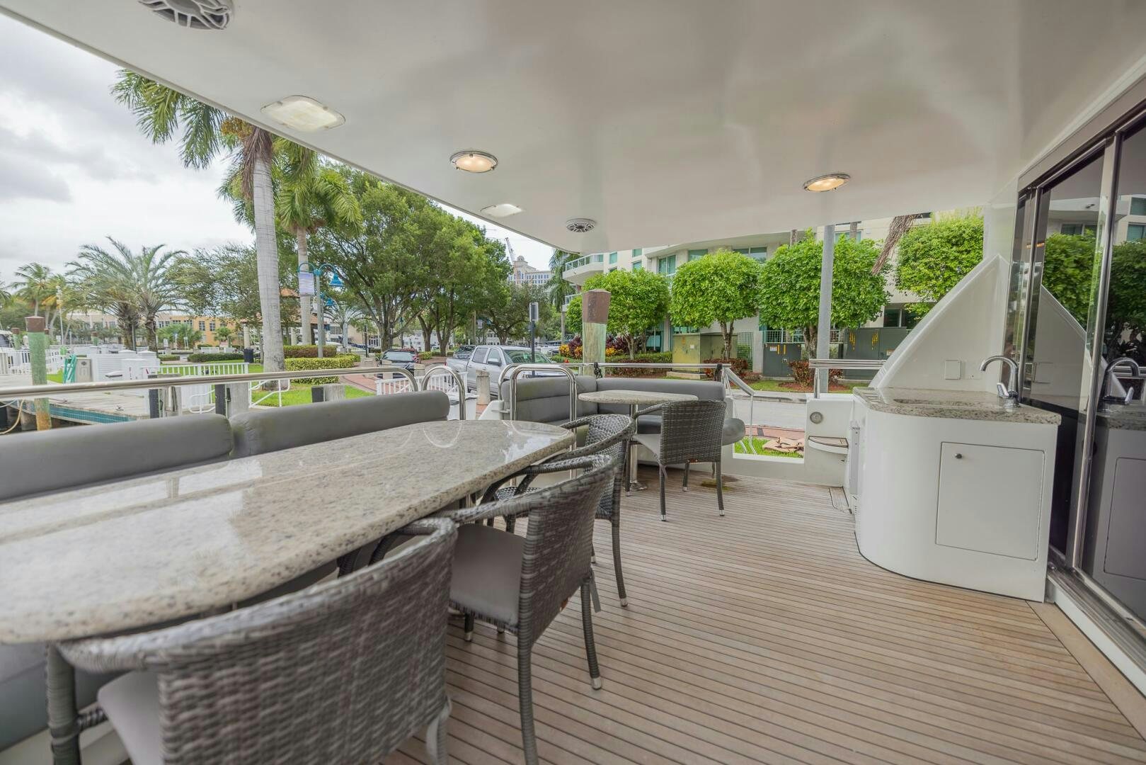 a deck with a table and chairs aboard BOURBON LEGEND Yacht for Sale