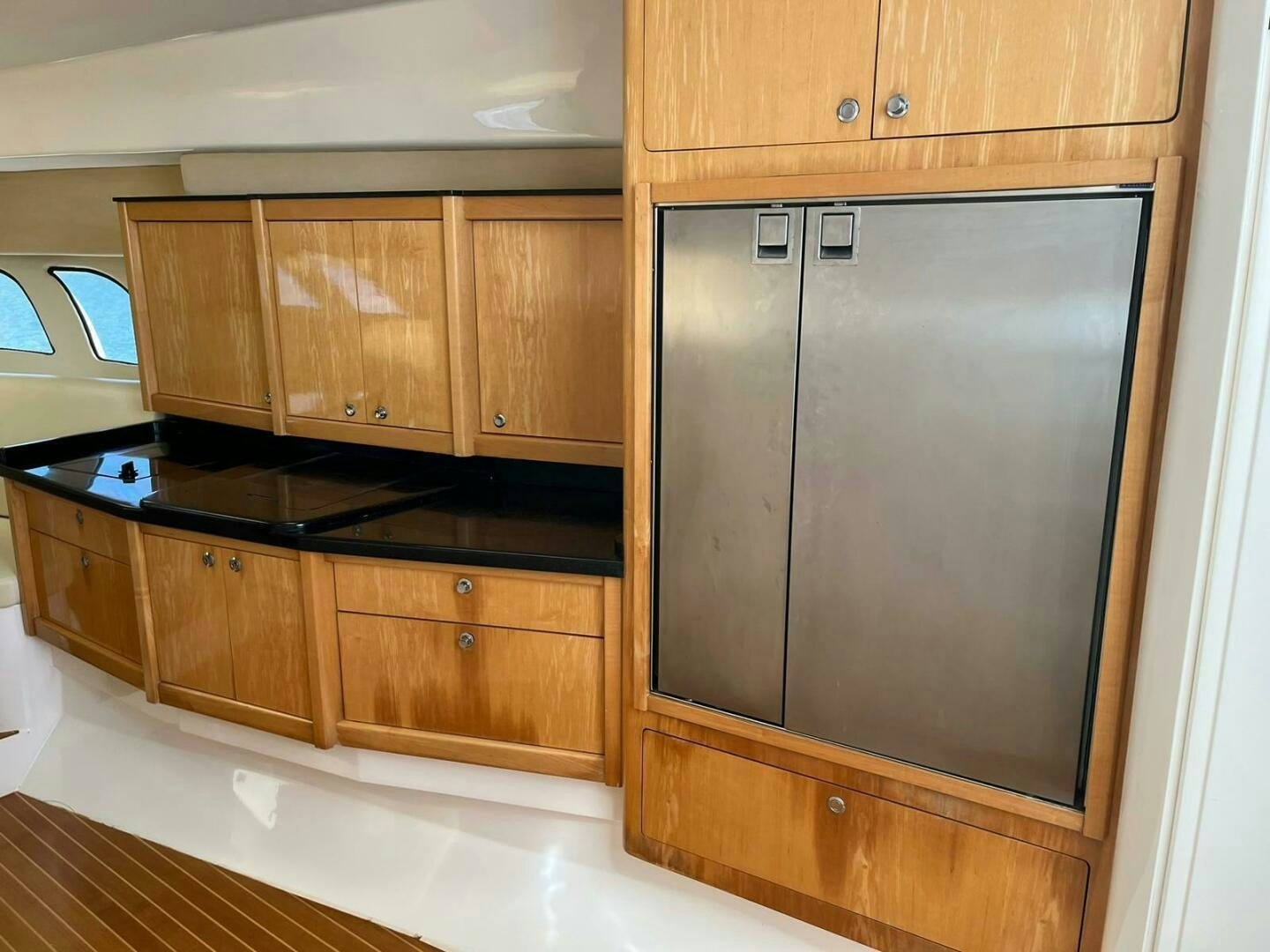 a kitchen with wooden cabinets aboard Forget about it. Yacht for Sale