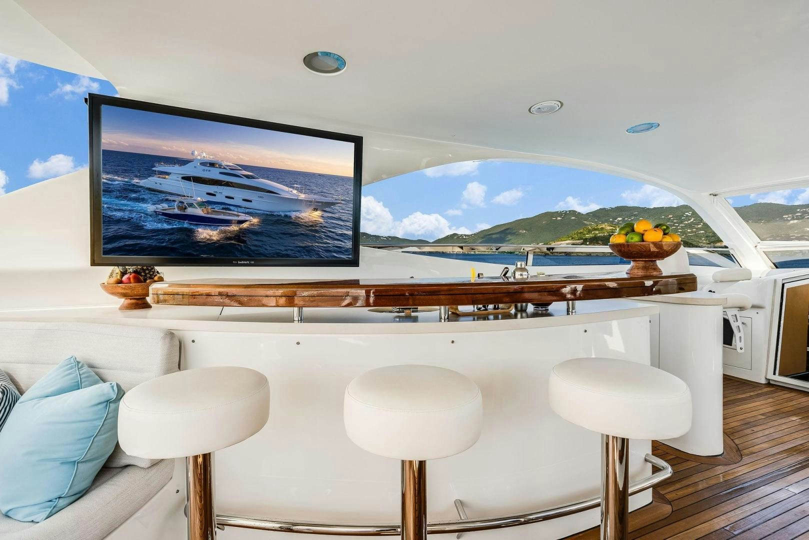 a room with a tv and stools aboard NAMASTAY Yacht for Sale