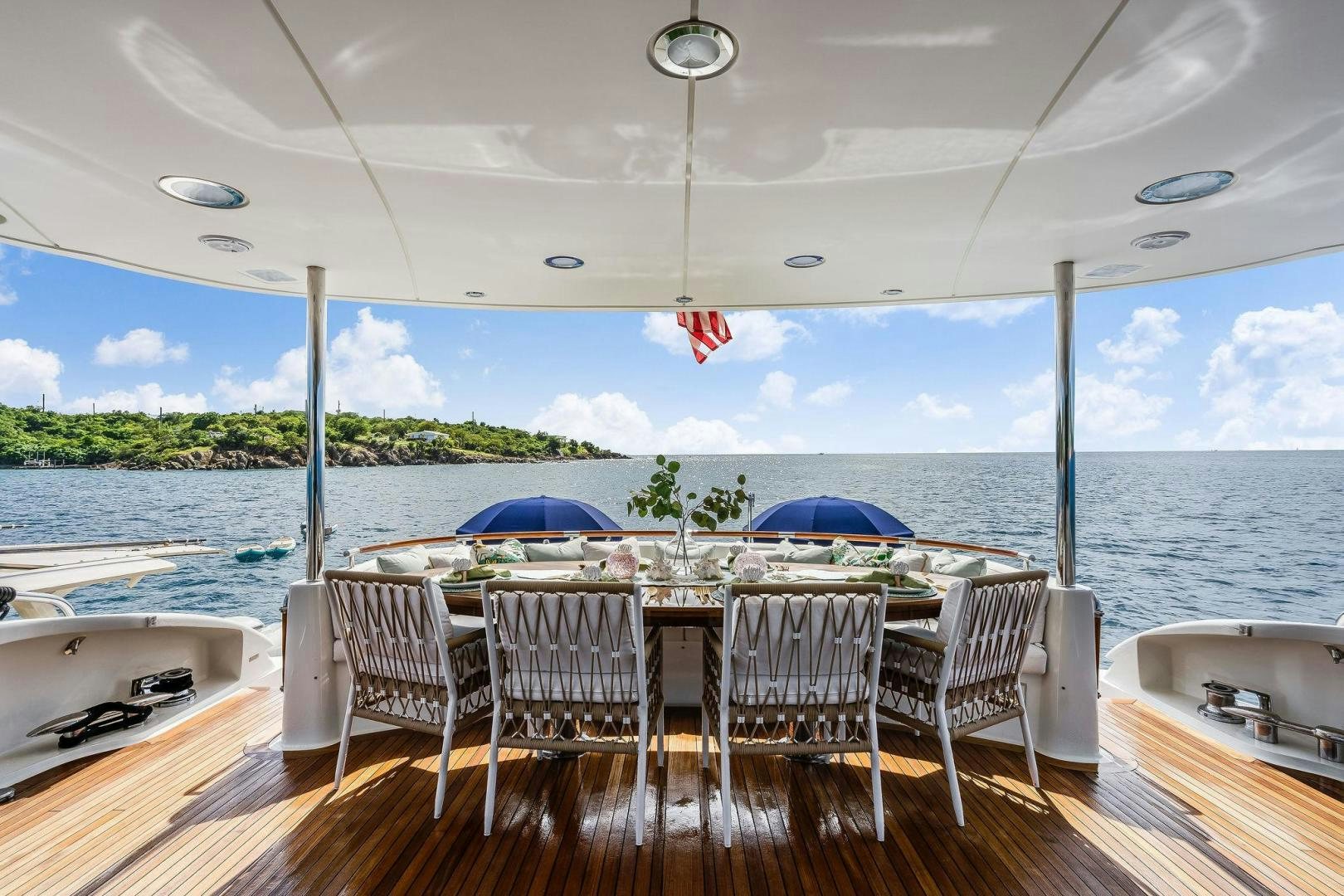 a table and chairs on a deck overlooking a body of water aboard NAMASTAY Yacht for Sale