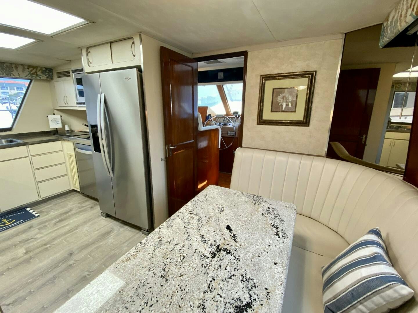 a living room with a couch and a kitchen in the background aboard CONUNDRUM Yacht for Sale