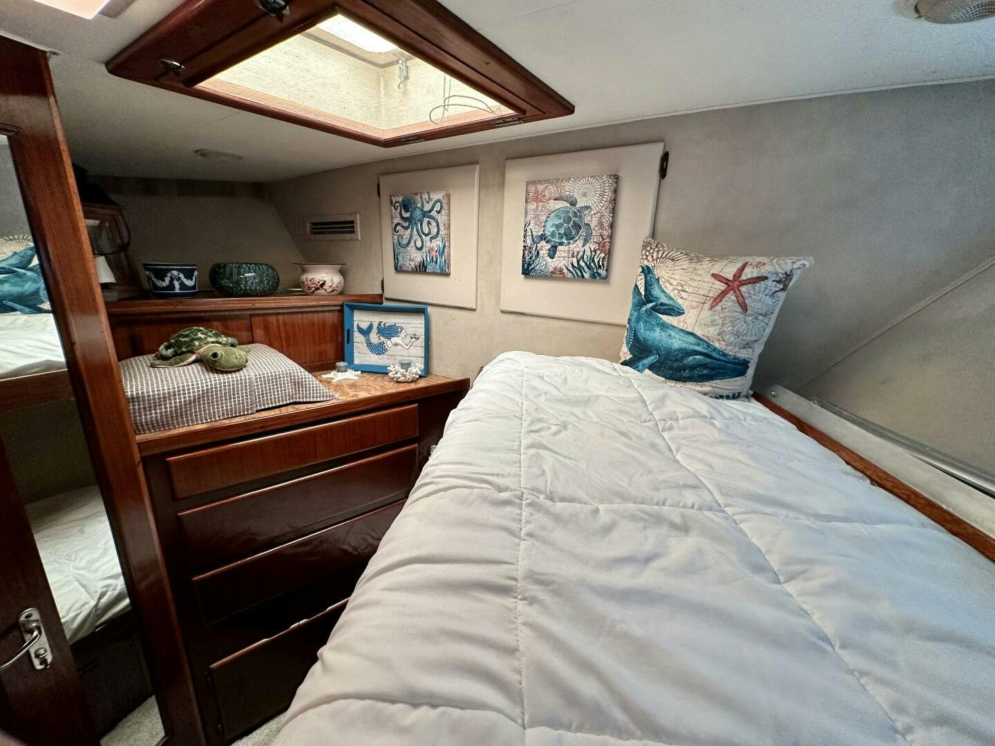 a bedroom with a bed and a dresser aboard CONUNDRUM Yacht for Sale
