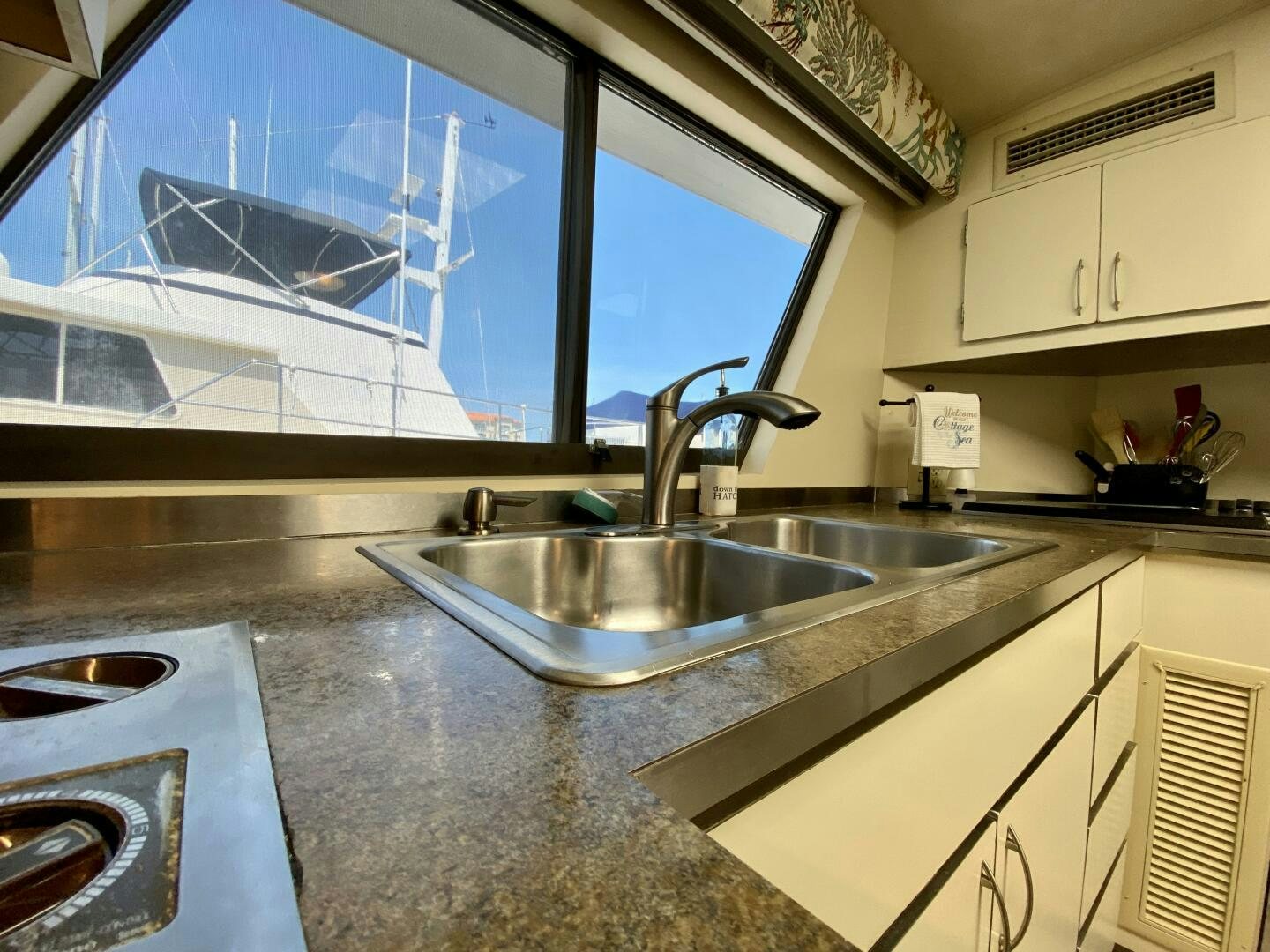 a kitchen with a sink and a large window aboard CONUNDRUM Yacht for Sale