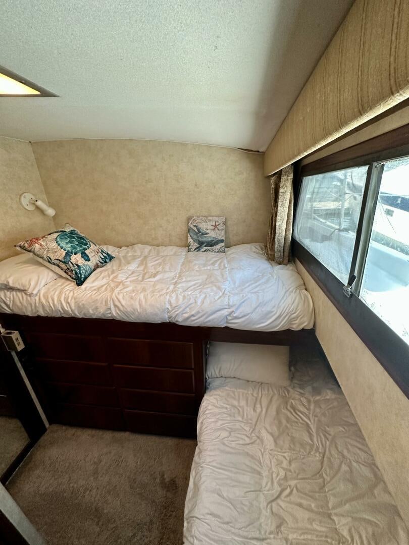 a bedroom with a bed and a window aboard CONUNDRUM Yacht for Sale
