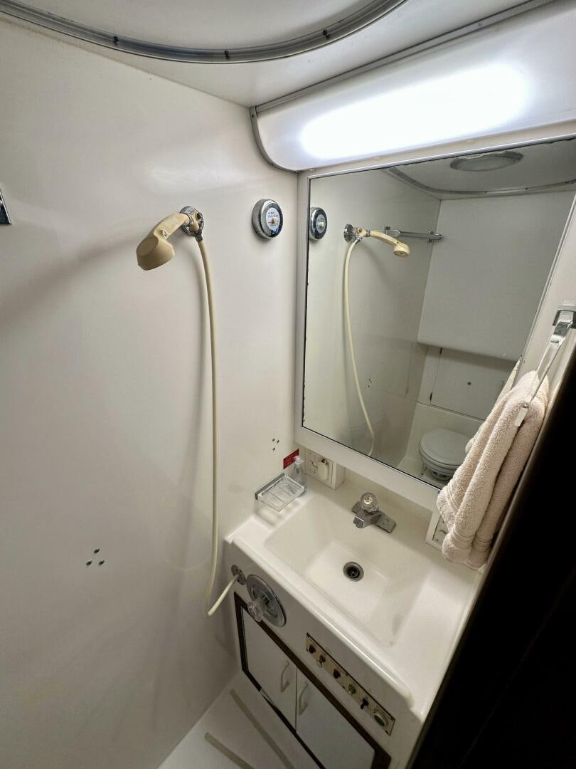 a bathroom with a shower and sink aboard CONUNDRUM Yacht for Sale