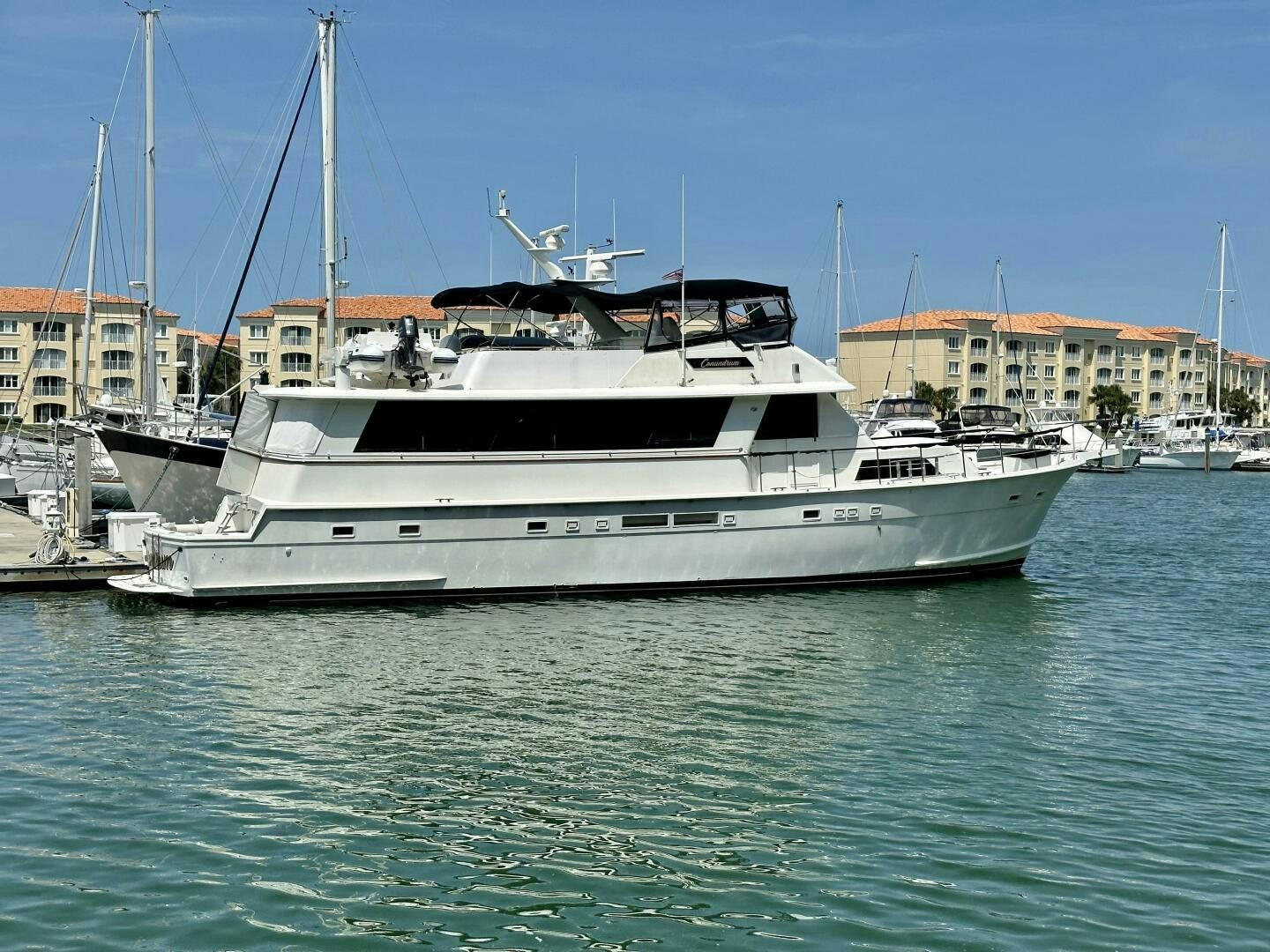 a large white boat in a harbor aboard CONUNDRUM Yacht for Sale