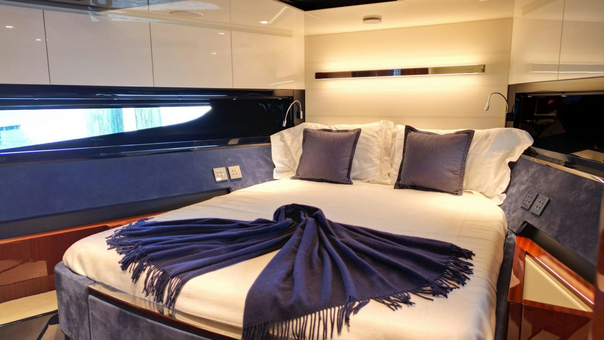 a bed with blue sheets aboard CAVALLO Yacht for Sale