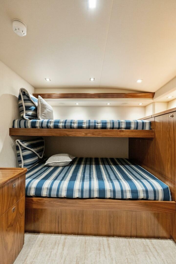 a bed with a blue and white striped blanket aboard SHOE  Yacht for Sale