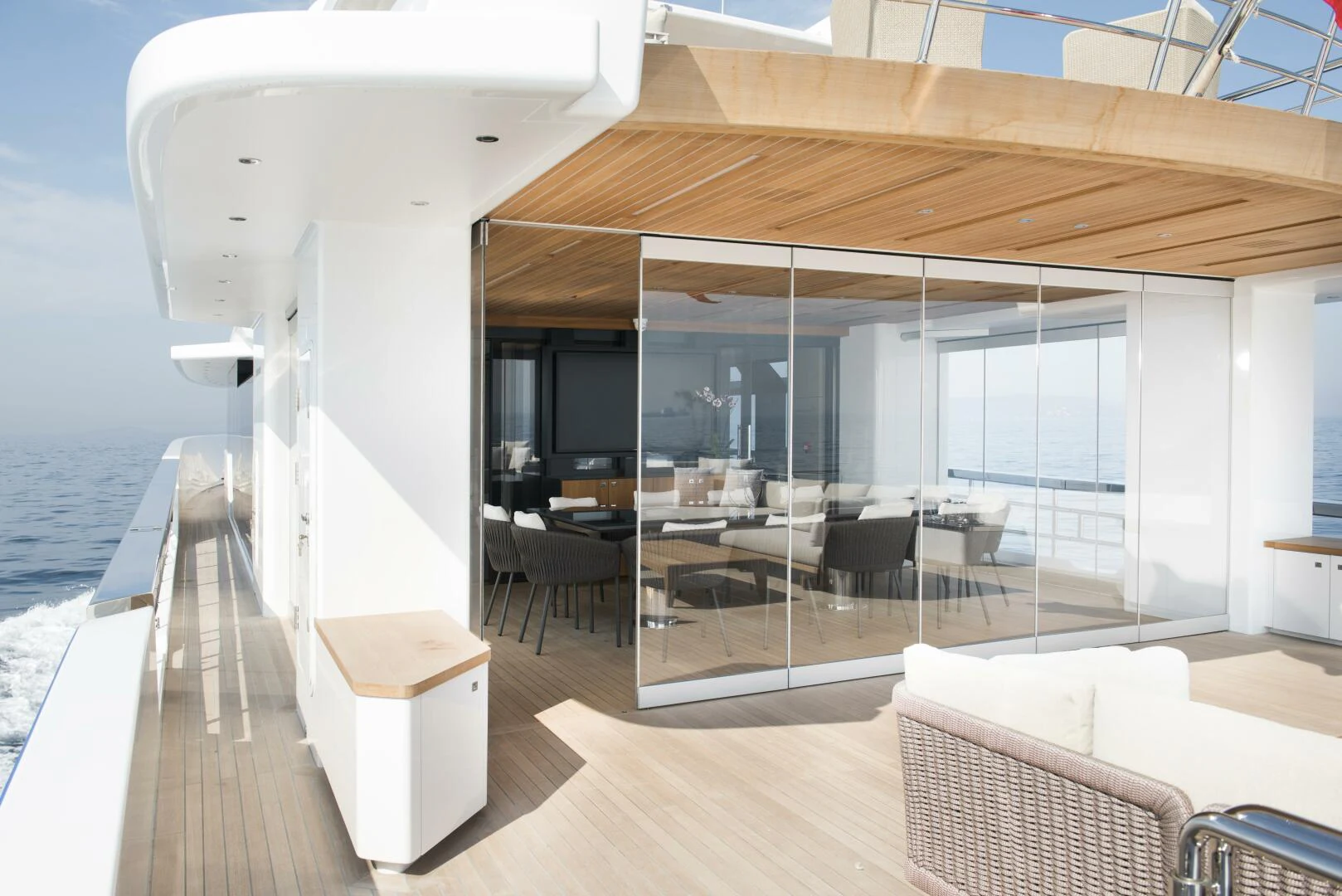 a room with a wood floor and a white lounge chair and a large white object on the floor aboard PICCOLO Yacht for Sale