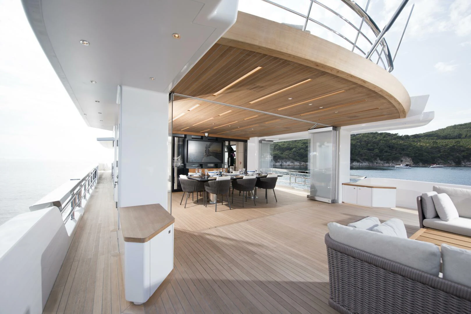 a large open area with a table and chairs and a large patio with a view of the water aboard PICCOLO Yacht for Sale