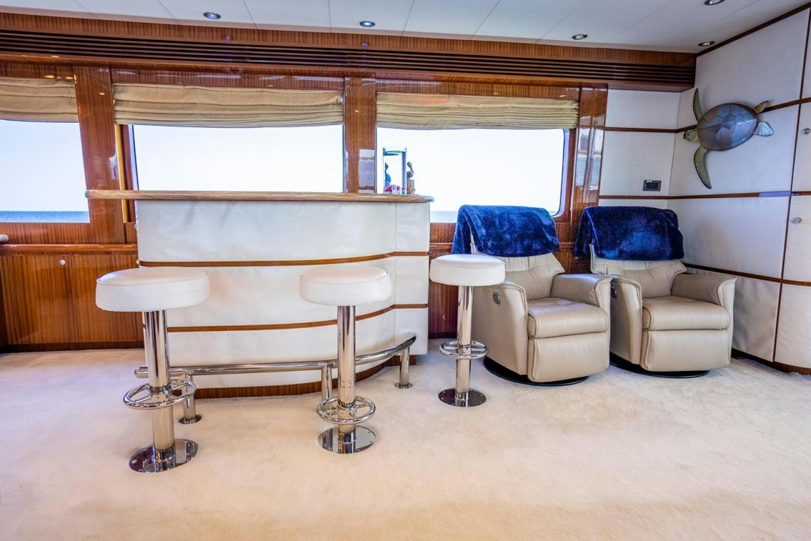 a room with a bench and chairs aboard AMERICAN HONEY Yacht for Sale