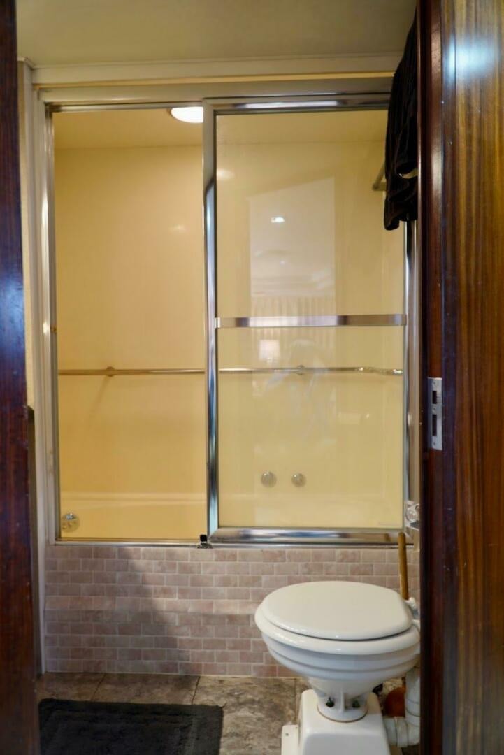 a bathroom with a glass shower door aboard JOIE DE VIE Yacht for Sale