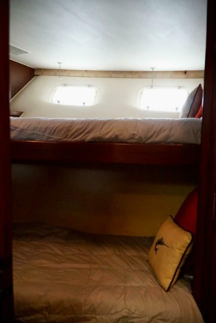 a bed with a pillow and a window aboard JOIE DE VIE Yacht for Sale