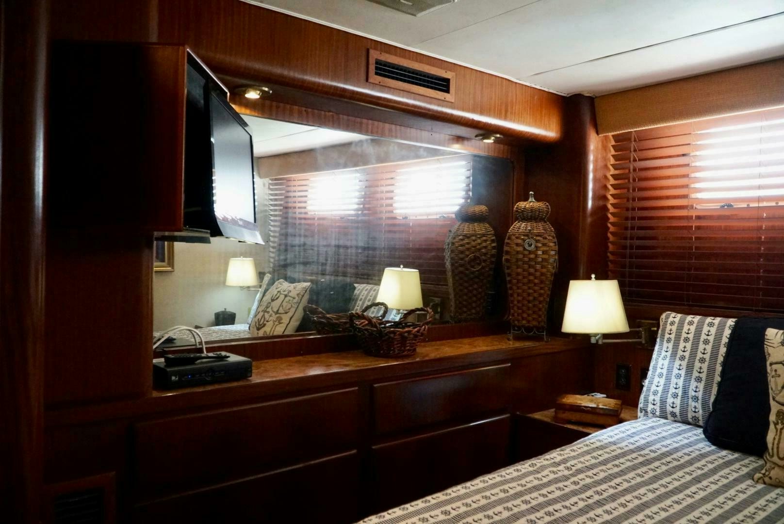 a bedroom with a large mirror aboard JOIE DE VIE Yacht for Sale