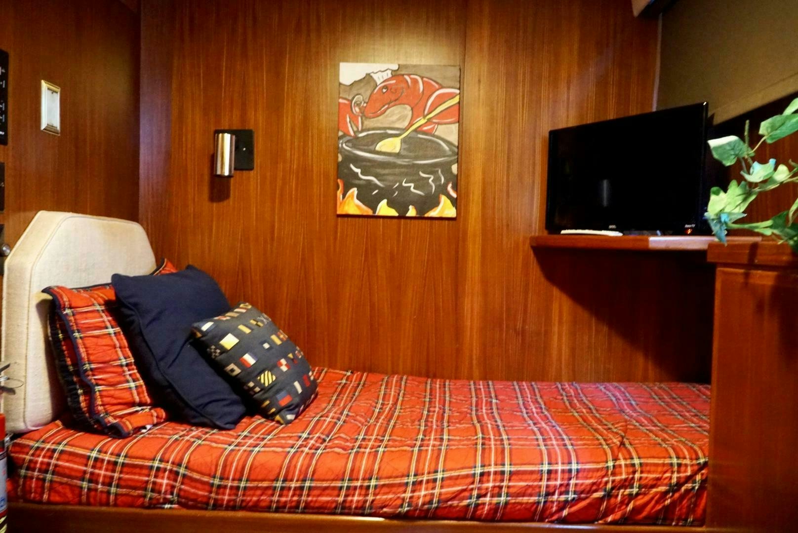 a bed with a red and white checkered blanket aboard JOIE DE VIE Yacht for Sale