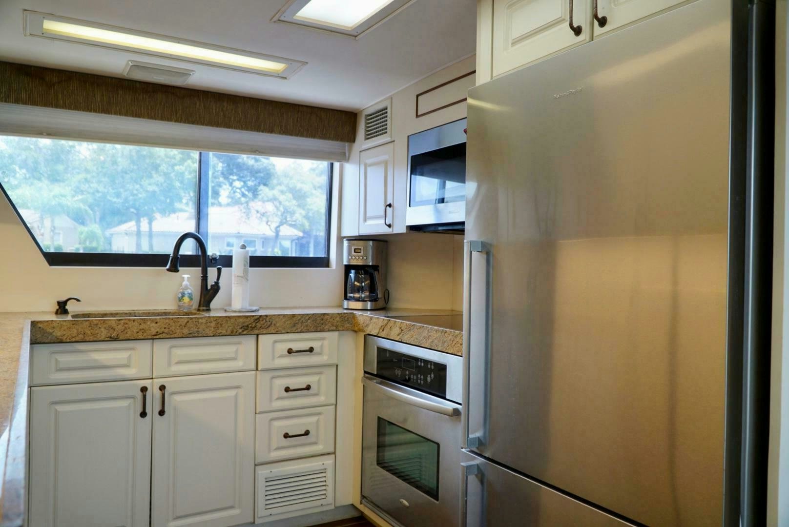a kitchen with a stainless steel refrigerator aboard JOIE DE VIE Yacht for Sale