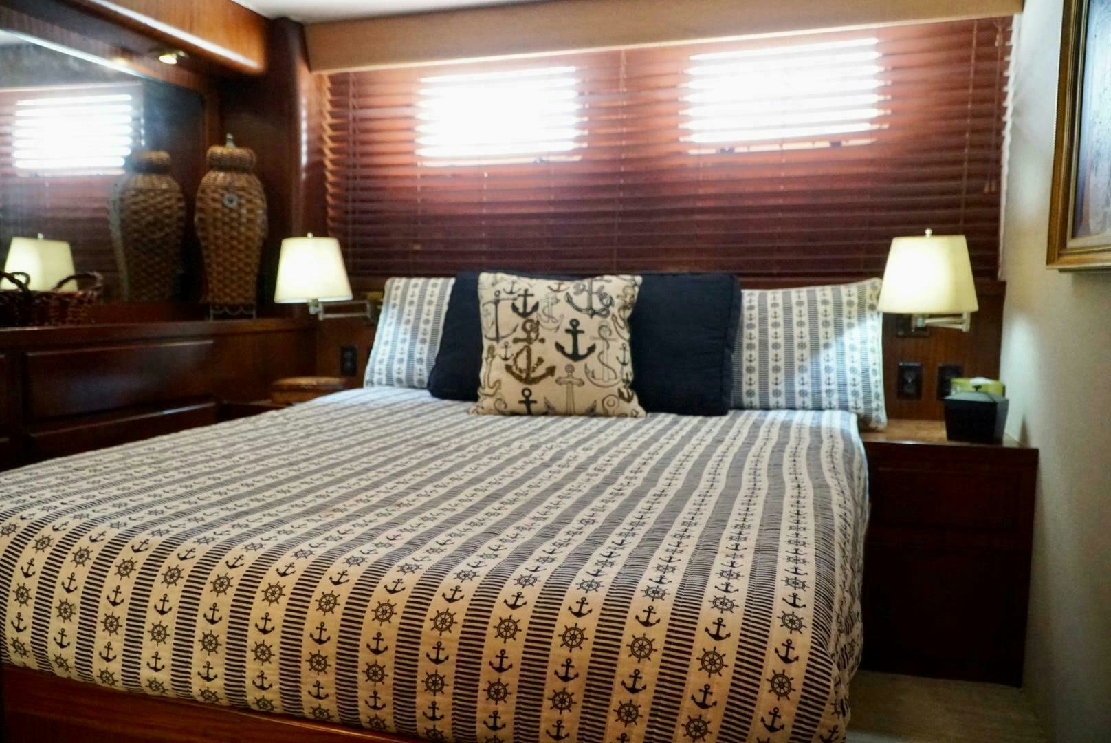 a bed with a pillow and a window aboard JOIE DE VIE Yacht for Sale
