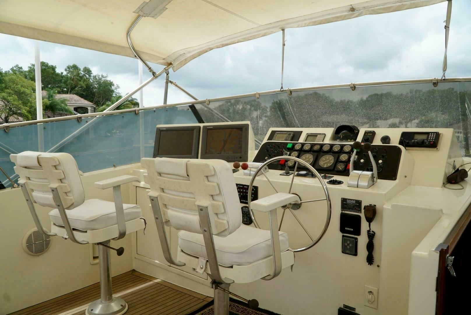 a room with a large white chair and a table with chairs and computers aboard JOIE DE VIE Yacht for Sale