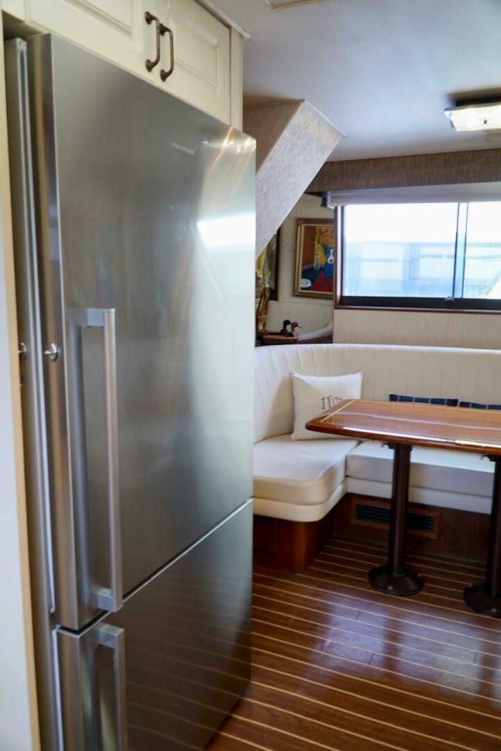 a refrigerator and a table in a room aboard JOIE DE VIE Yacht for Sale