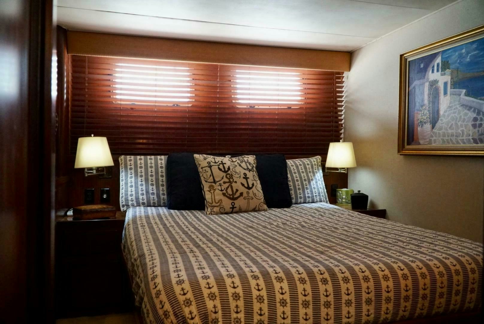 a bed with a painting on the wall aboard JOIE DE VIE Yacht for Sale