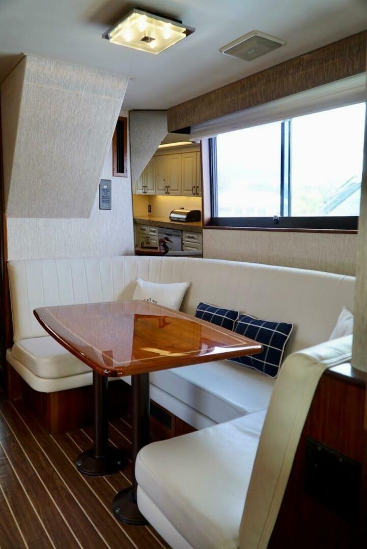 a living room with a table and chairs aboard JOIE DE VIE Yacht for Sale