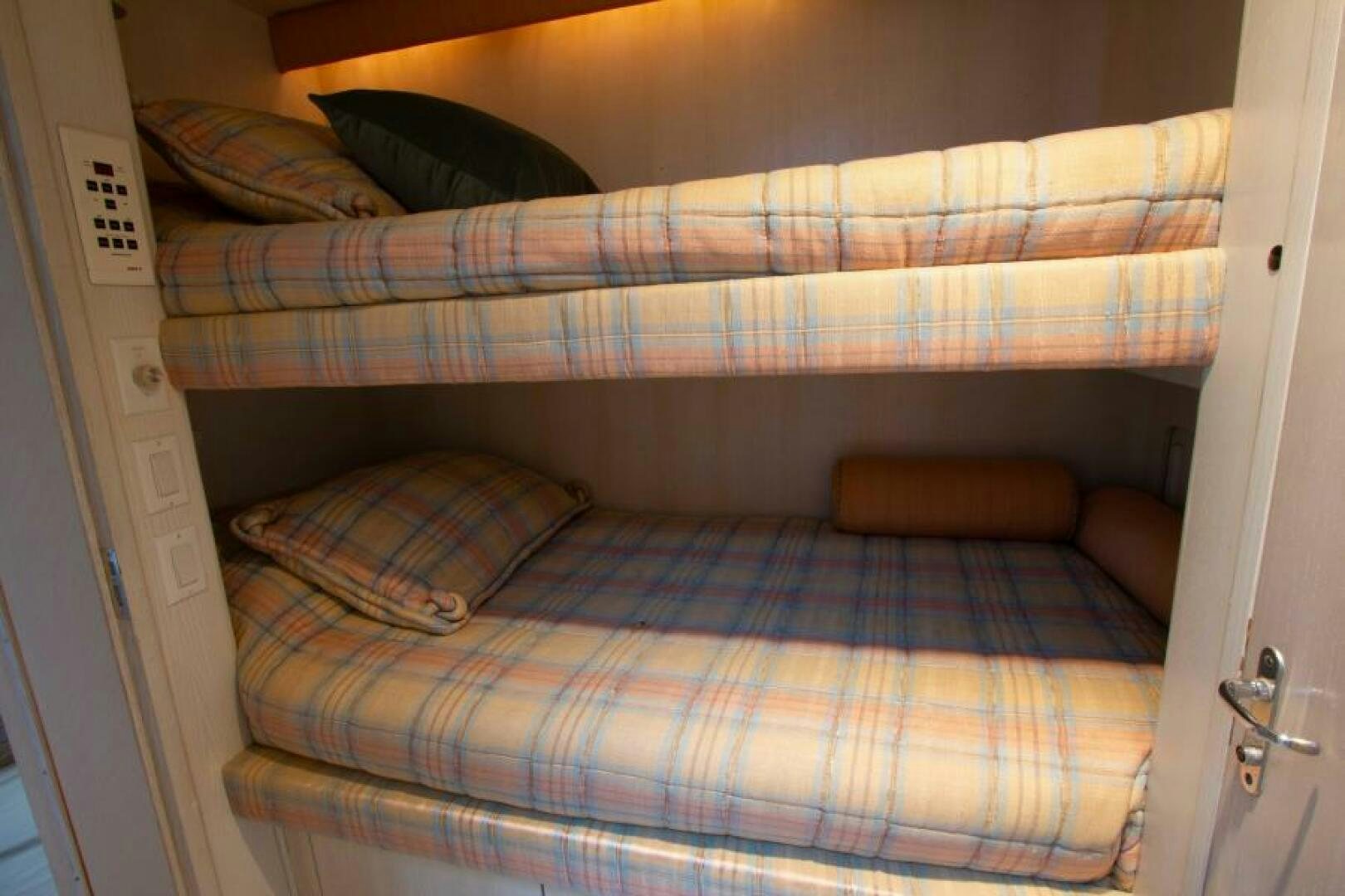a bed with a plaid sheet aboard FULL MOON Yacht for Sale