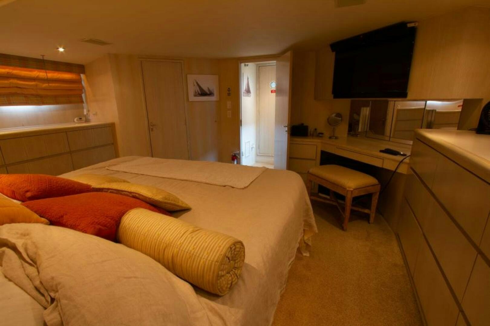 a bedroom with a bed and desk aboard FULL MOON Yacht for Sale