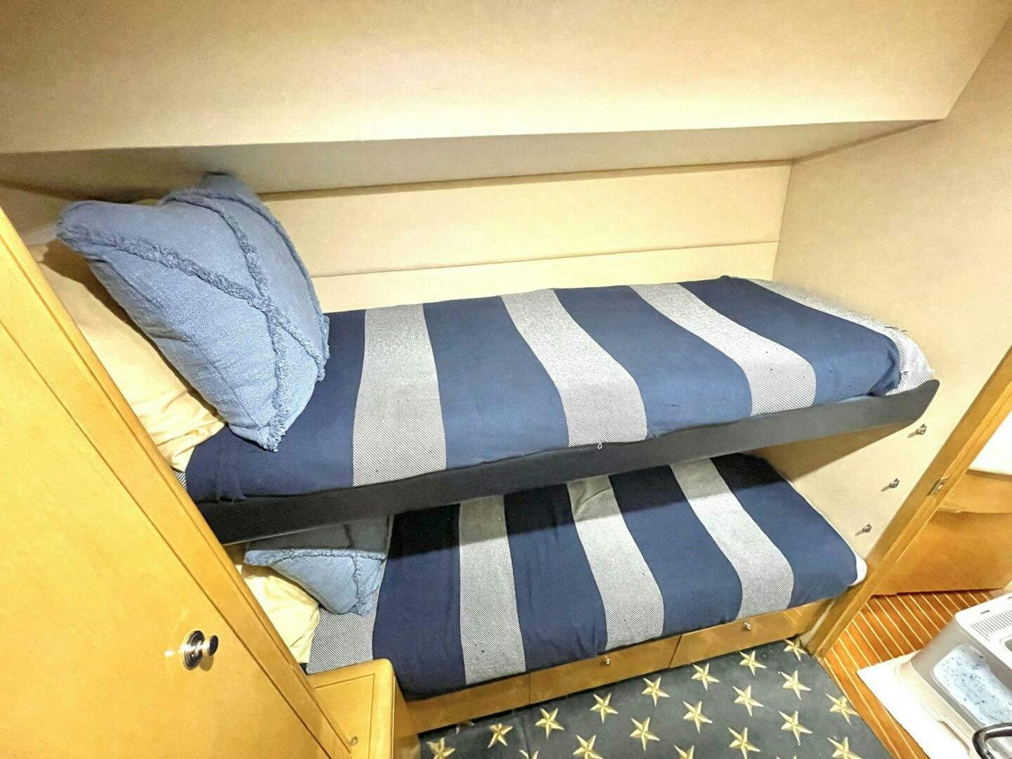 a bed with a striped blanket aboard BOATOX Yacht for Sale