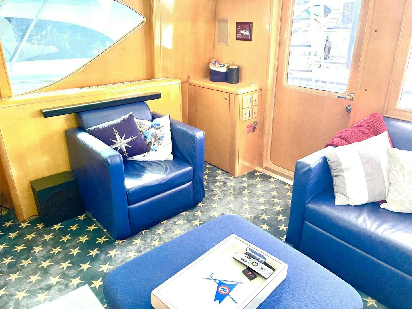 a living room with a blue couch and a television aboard BOATOX Yacht for Sale