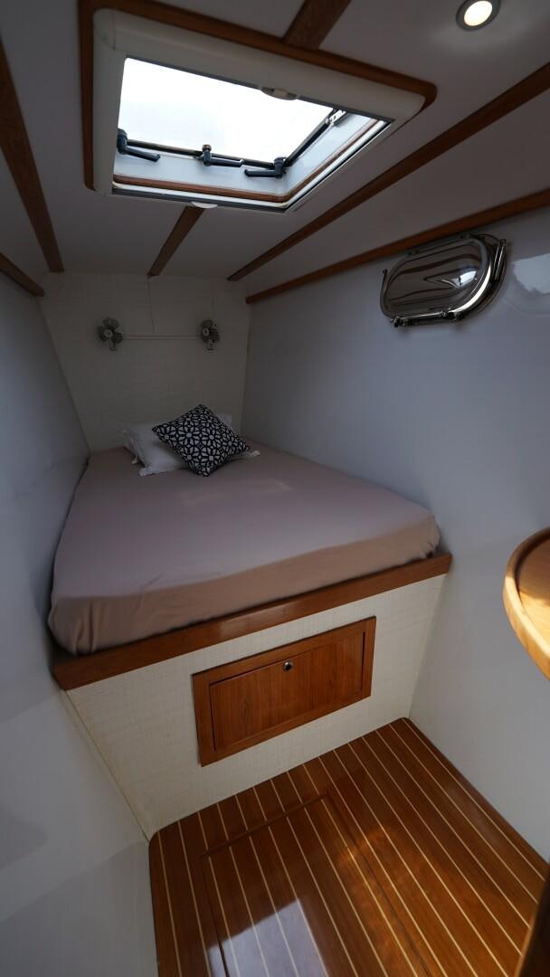 a bed with a white bed and a wooden headboard aboard SOVEREIGN Yacht for Sale