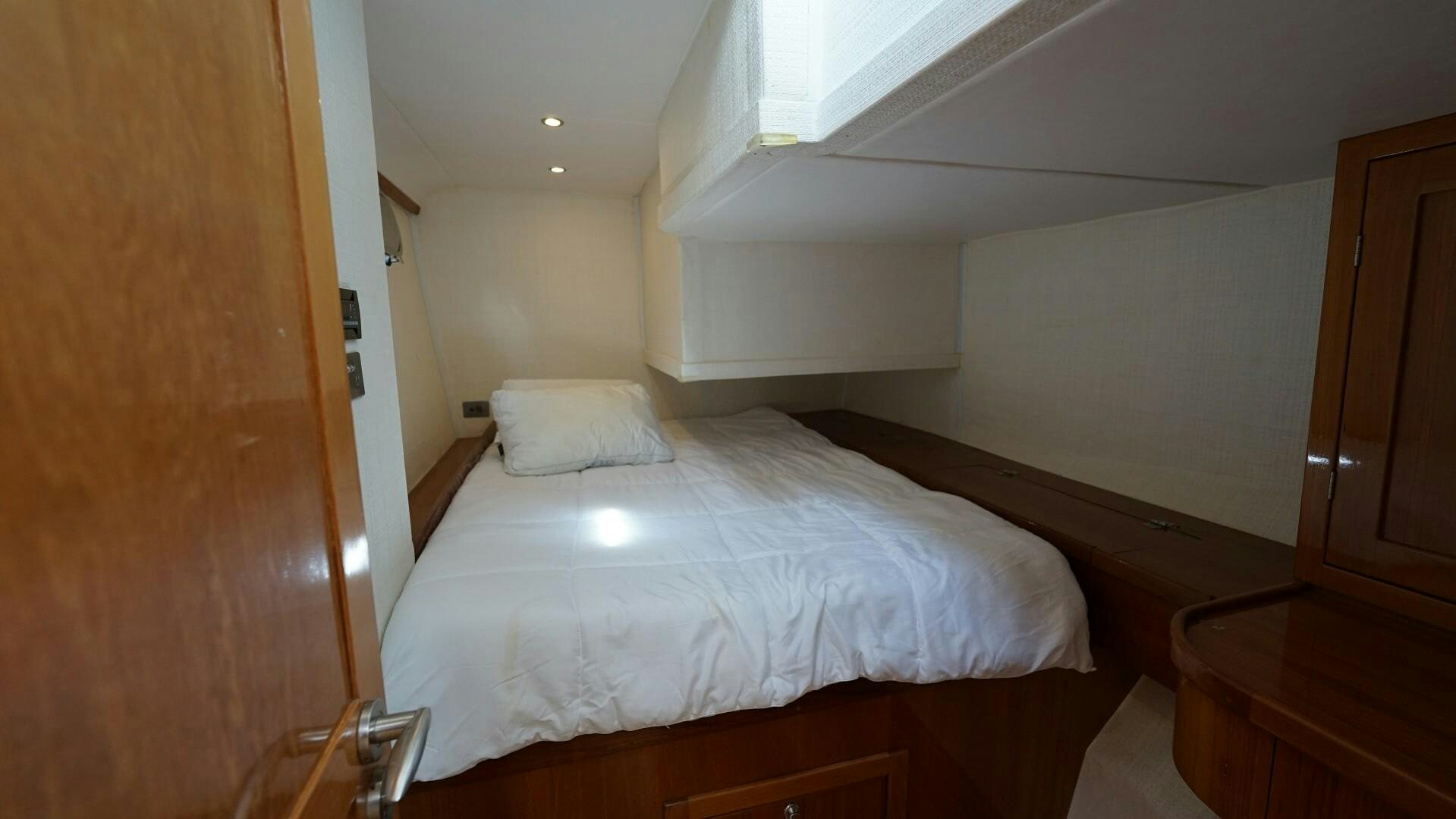 a room with a bed and cabinets aboard SOVEREIGN Yacht for Sale