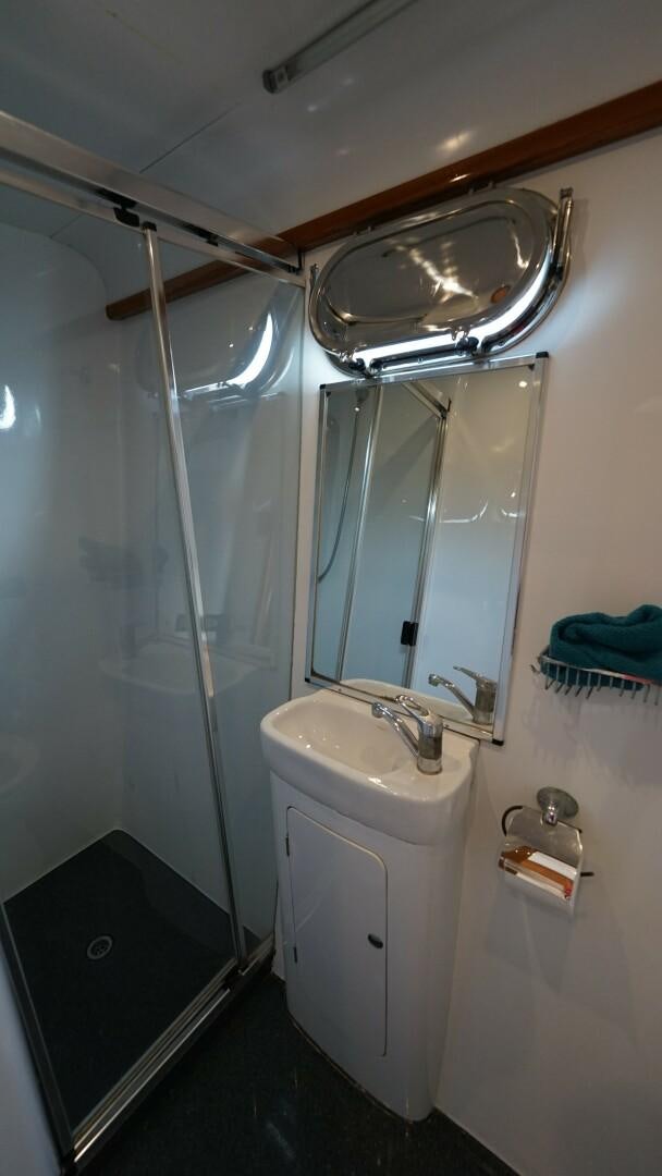 a bathroom with a shower and sink aboard SOVEREIGN Yacht for Sale