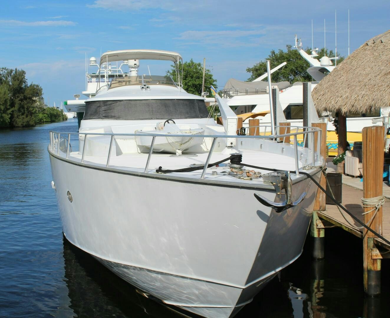 a white boat docked at a pier aboard PRICELESS Yacht for Sale