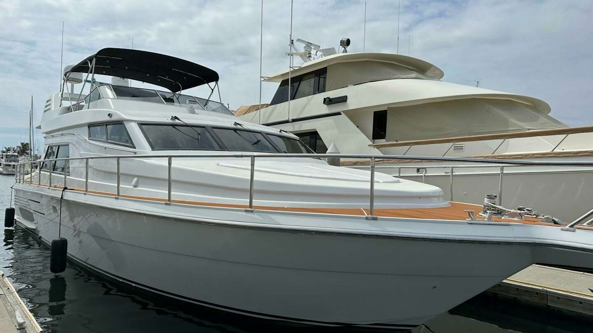 a white yacht in a harbor aboard LUNADA Yacht for Sale