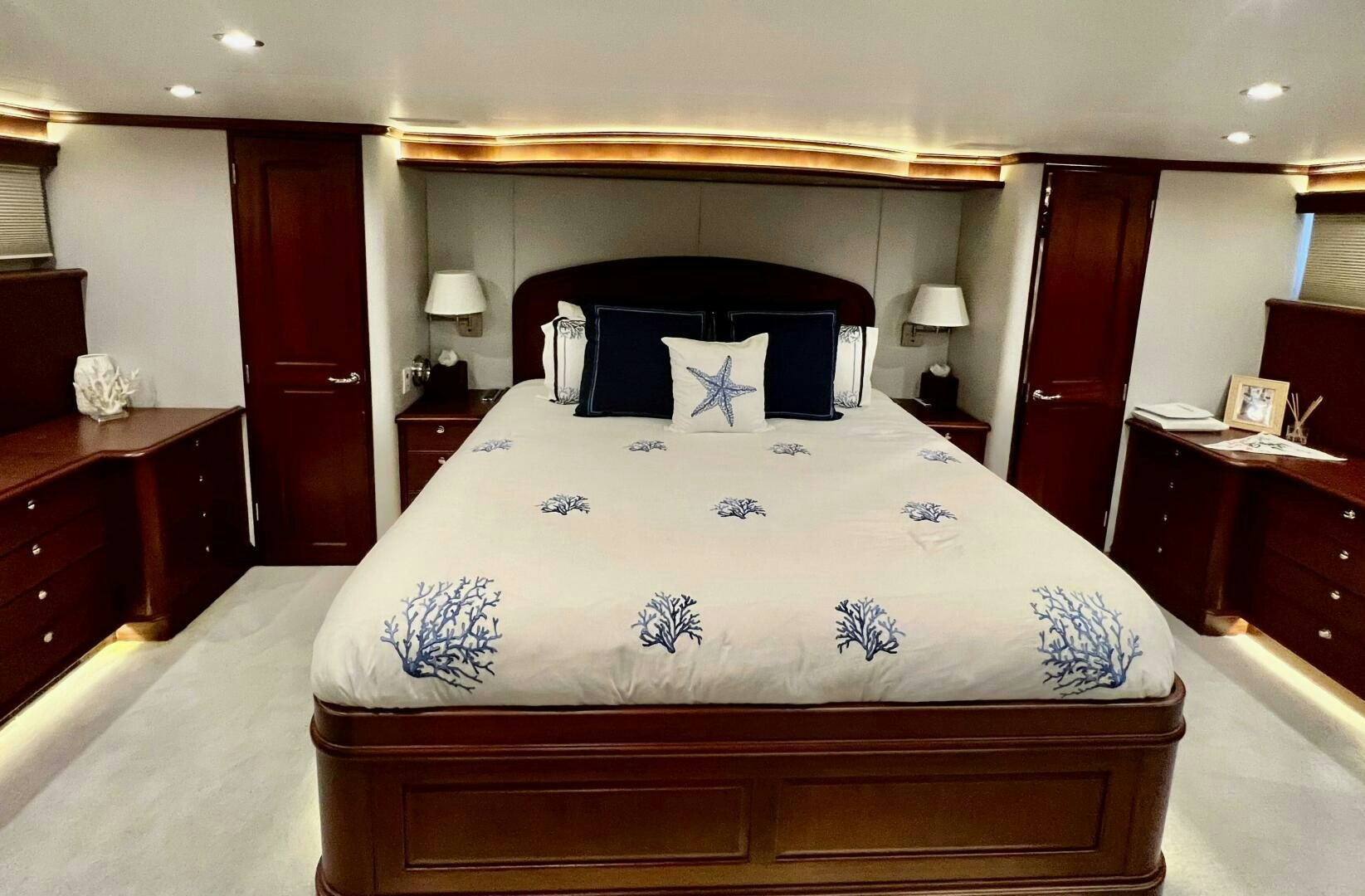 a bed with a blue and white comforter and pillows aboard LADY B Yacht for Sale
