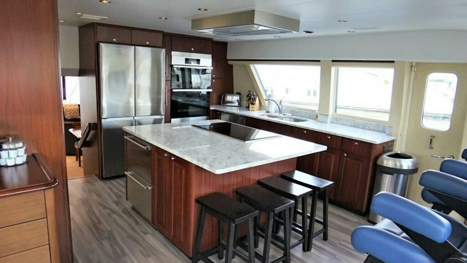 a kitchen with a bar stools and a bar stool aboard LADY B Yacht for Sale